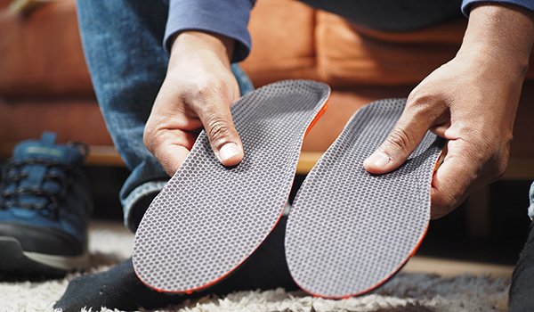 men-hand-putting-orthopedic-insoles-in-shoes-NF-Podiatry men-hand-putting-orthopedic-insoles-in-shoes-NF-Podiatry